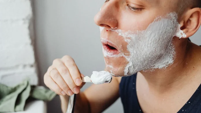 Shaving Cream and Aftershave Man applying shaving cream with a brush