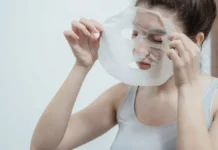 Sheet Masks: How Often to Use Them and What They Can’t Do Woman applying a hydrating sheet mask