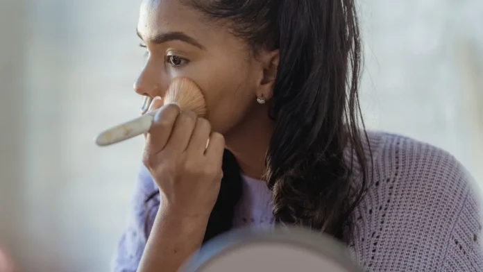 SPF Makeup Woman applying foundation makeup with SPF
