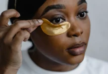 Under-Eye Masks and Patches: Real Benefit or Temporary Fix? Woman applying gold under-eye patches