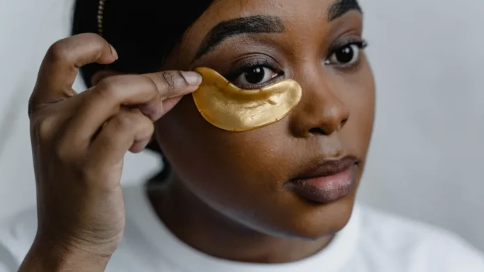 Under-Eye Masks Woman applying gold under-eye patches
