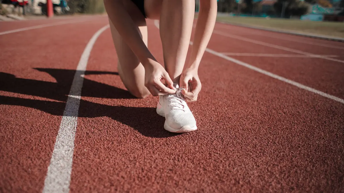 Runner tying a shoe on an outdoor track