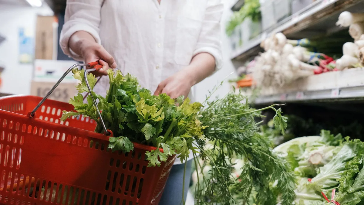 Grocery basket filled with fresh green vegetables