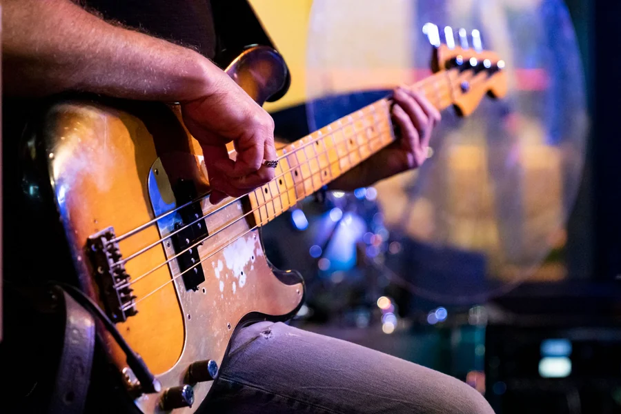 Bill Wyman net worth - close up of a vintage bass guitar being played live