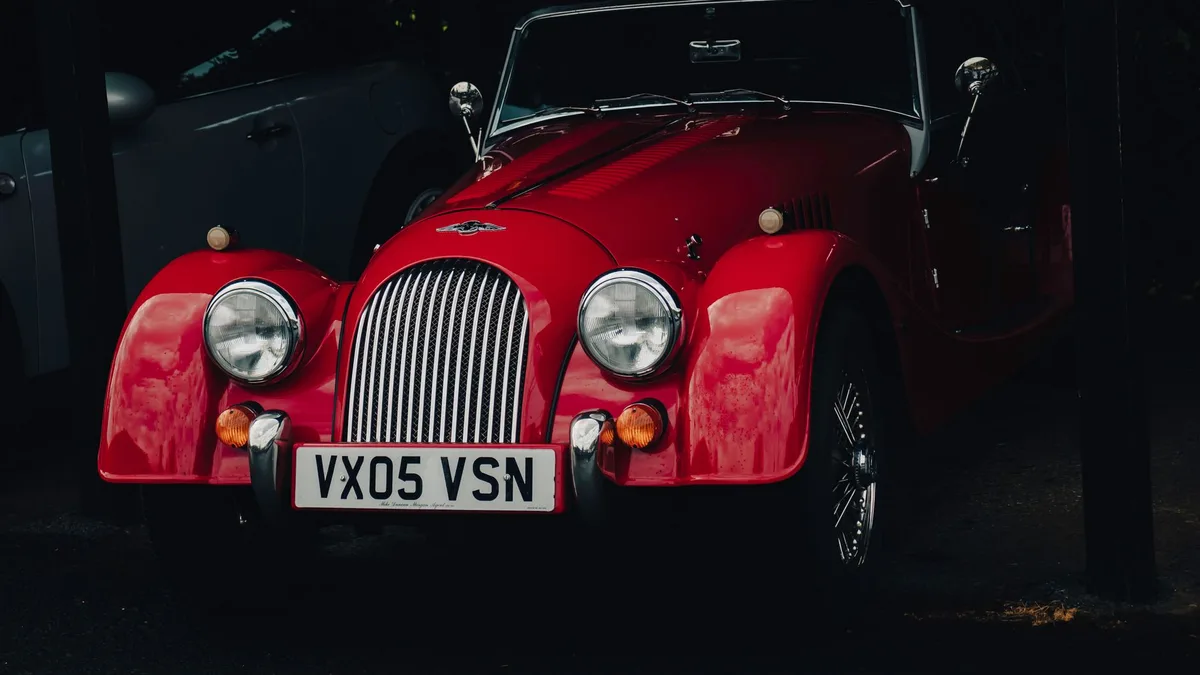 Classic red convertible car in a dimly lit showroom