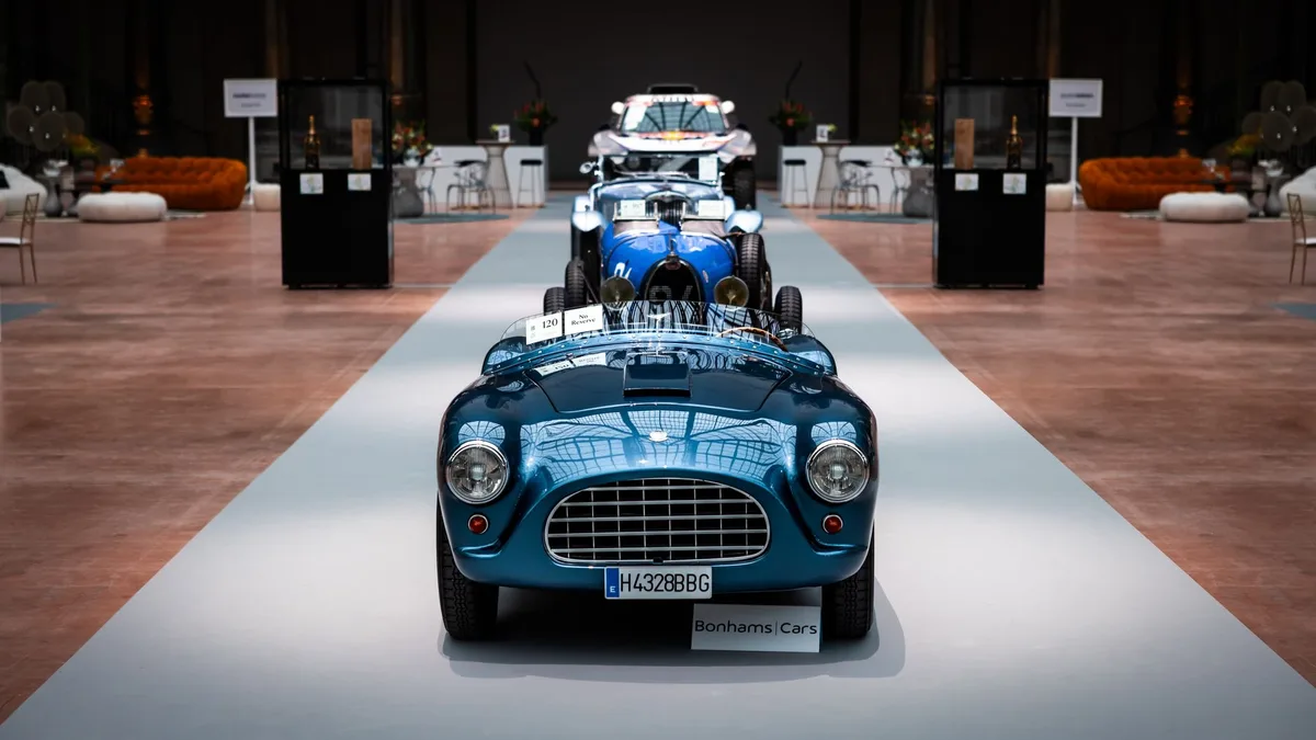 Vintage cars lined up inside a showroom
