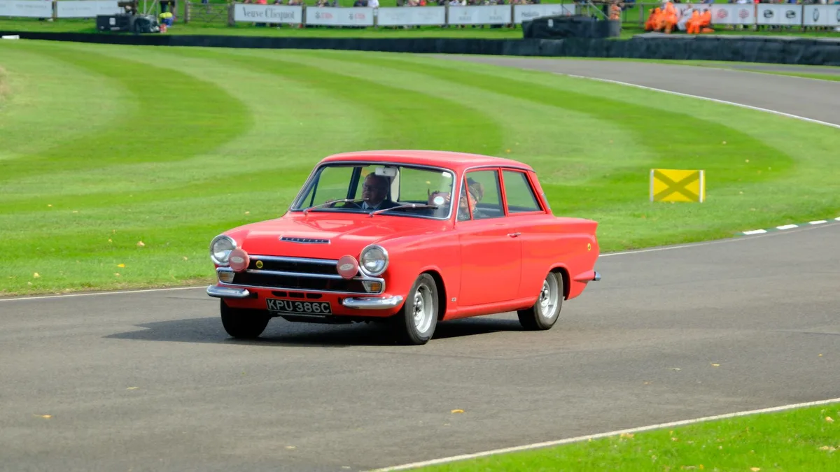 Classic red Ford Cortina at a historic racing circuit