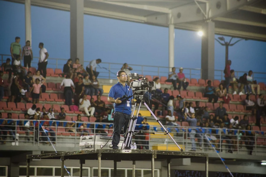 Don King net worth - cameraman filming at a crowded stadium event