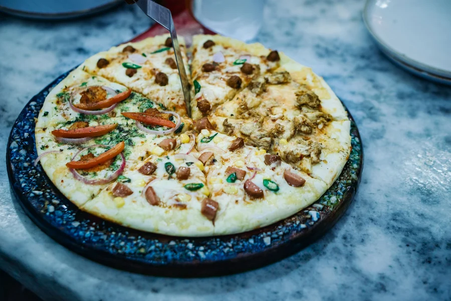 Double cut pizza - sliced pizza with mixed toppings on a round platter