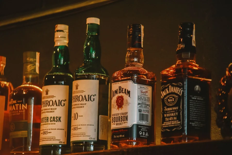 Jay-Z net worth - premium spirits bottles arranged on a dimly lit bar