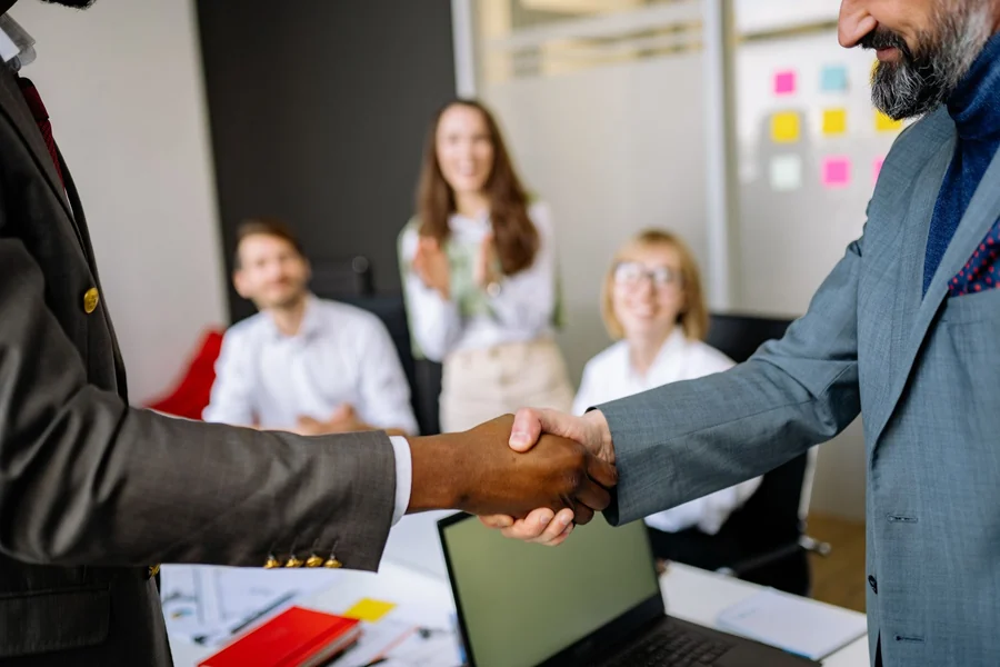 Jay-Z net worth - close-up of a handshake in a professional office