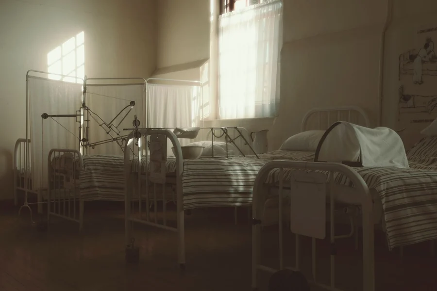 Jimmy Savile - dimly lit vintage hospital room with empty beds