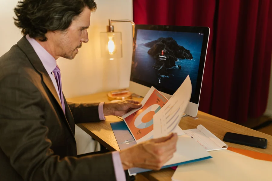 Jimmy Savile - a professional reading printed reports at a desk