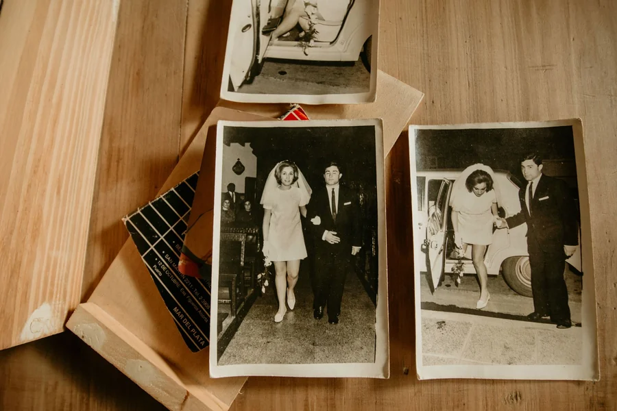 John Candy net worth - vintage black and white wedding photographs on a table