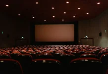 John Candy Net Worth: What He Earned and What He Left John Candy net worth - dimly lit empty cinema with rows of red seats
