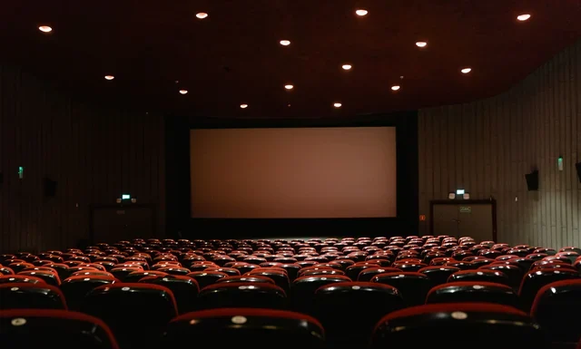 John Candy Net Worth: What He Earned and What He Left John Candy net worth - dimly lit empty cinema with rows of red seats
