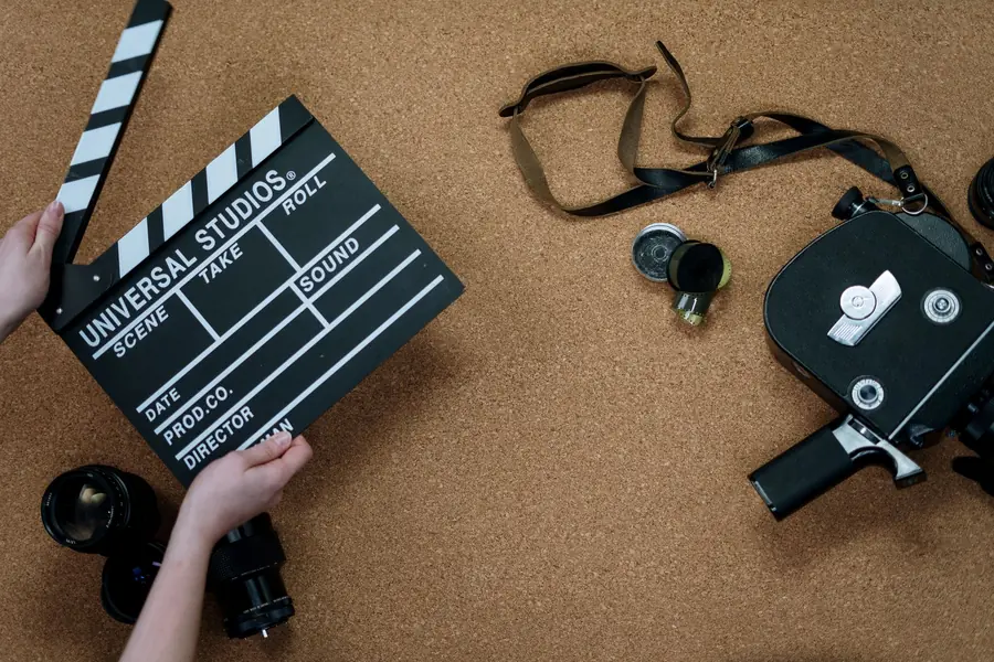 Kevin Spacey net worth - vintage film camera and clapperboard on a desk