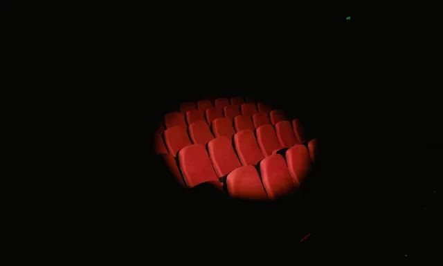 Kevin Spacey Net Worth 2026: What He Actually Owes Now Kevin Spacey net worth - rows of red theatre seats spotlighted in a dark auditorium