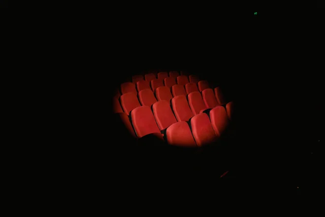Kevin Spacey Net Worth 2026 Kevin Spacey net worth - rows of red theatre seats spotlighted in a dark auditorium