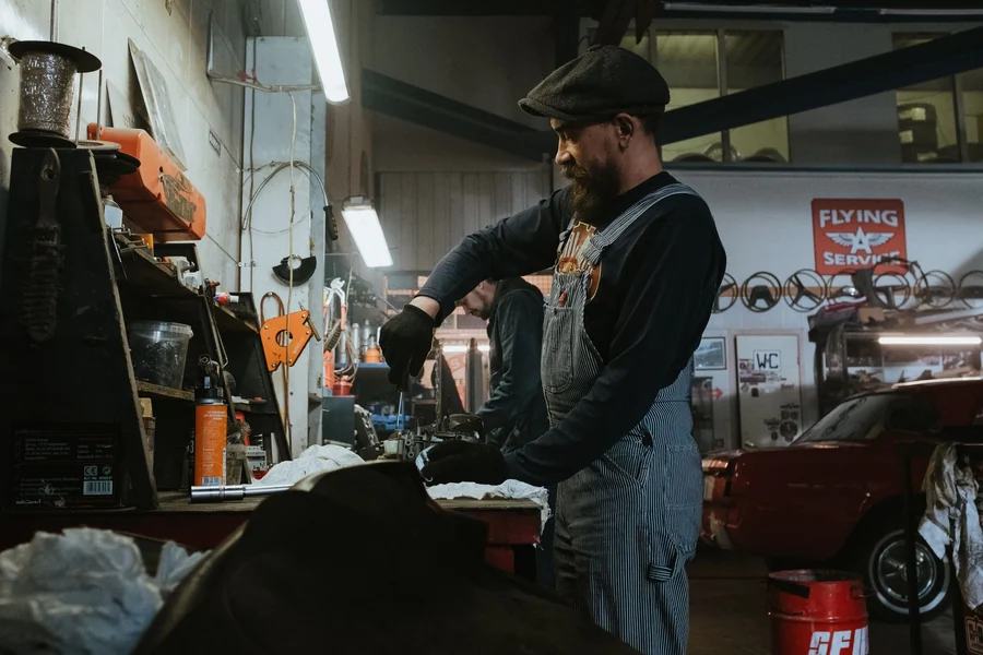 Kylie Minogue net worth - mechanic repairing a car in a vintage garage