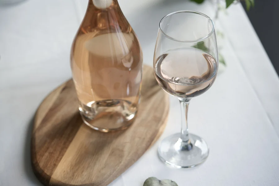Kylie Minogue net worth - rose wine bottle and glass on a wooden board