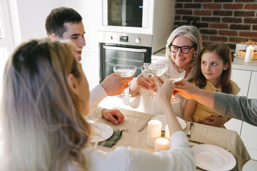 Lecy Goranson net worth - multiple generations toasting around a family table