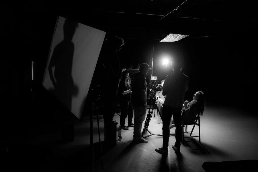 Lecy Goranson net worth - black and white image of a film crew on set