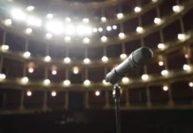 Louis Walsh Net Worth 2026: How a Pop Manager Gets Paid Louis Walsh net worth - microphone on stage under bright theatre lights