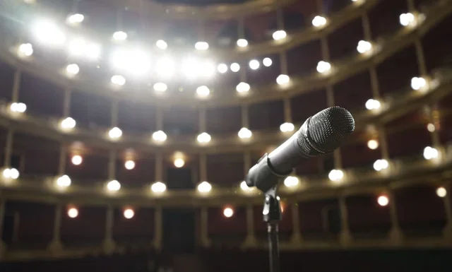 Louis Walsh Net Worth 2026: How a Pop Manager Gets Paid Louis Walsh net worth - microphone on stage under bright theatre lights