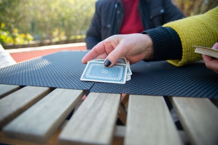 Memory matching game - hands arranging playing cards on a table