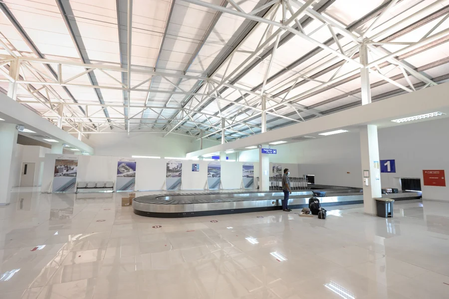 Princess Traveller suitcase review - traveller waiting at an airport baggage claim belt