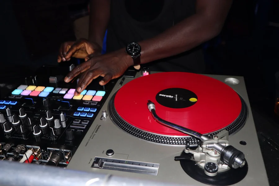 Snoop Dogg net worth - DJ mixing on a red vinyl turntable