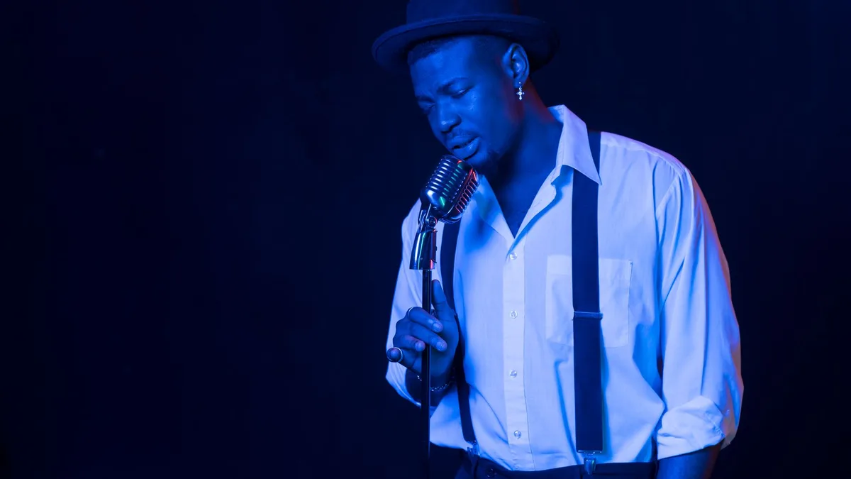 Vocalist singing under blue stage lighting