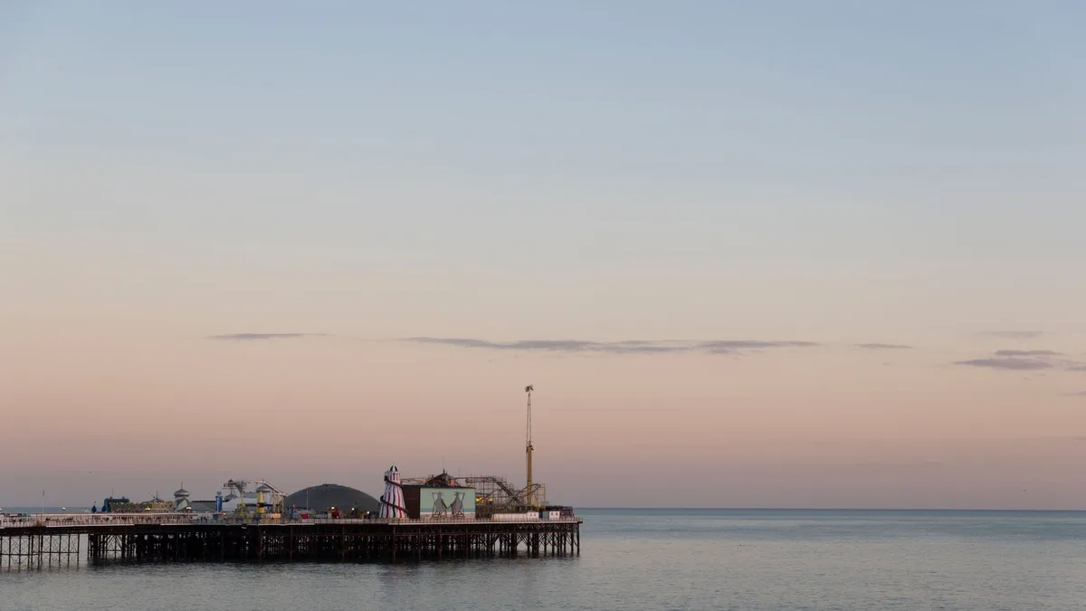 Brighton Pier at sunset over a calm sea