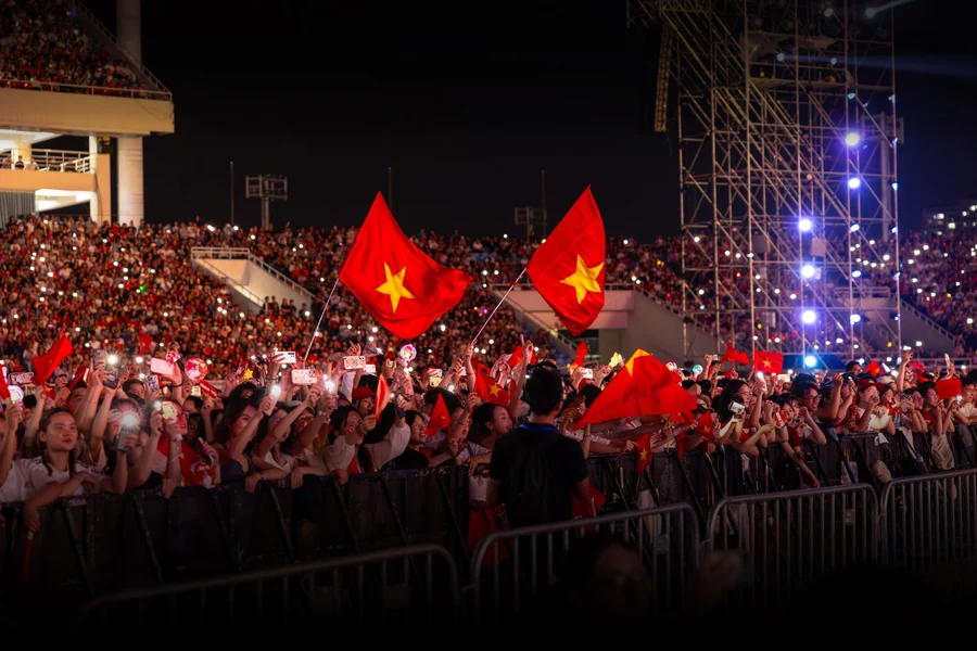 Taylor Swift net worth - huge crowd at a night concert under bright lights