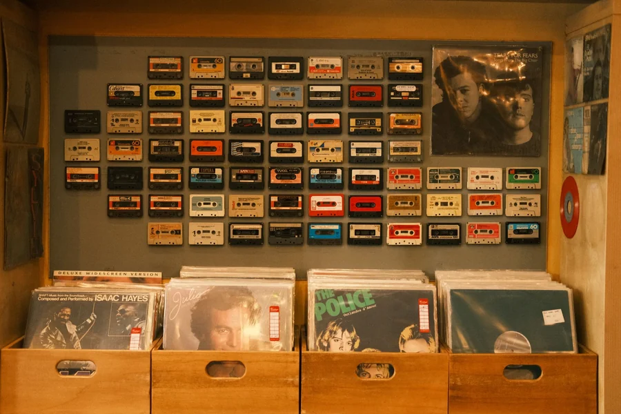 Taylor Swift net worth - wall of cassettes above vinyl records in a music shop
