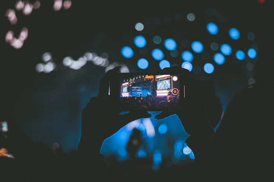 Taylor Swift net worth - live concert seen through a smartphone screen