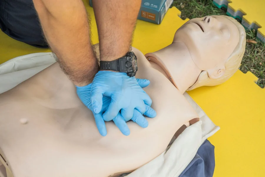 Vinnie Jones net worth - hands performing CPR on a training manikin
