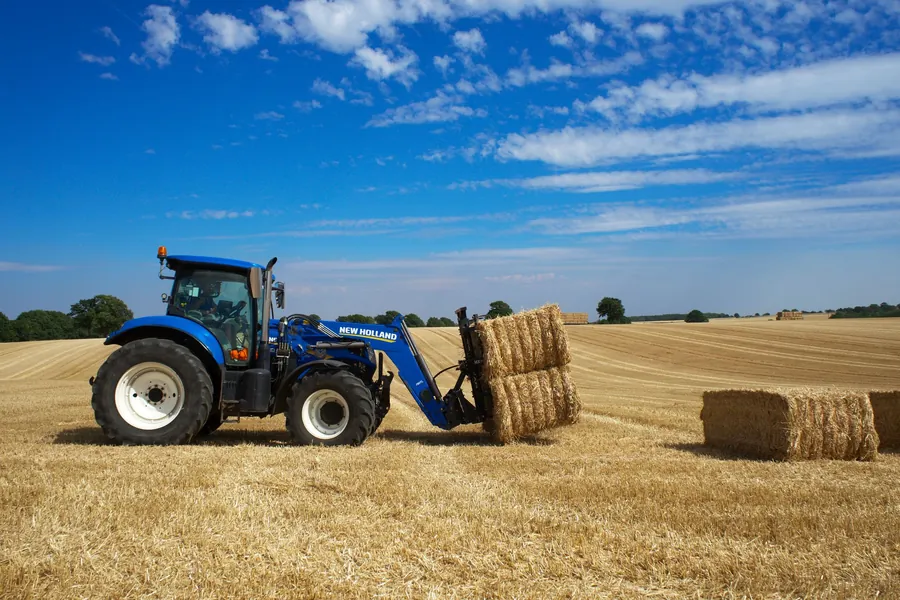 Vinnie Jones net worth - tractor collecting hay bales in an English field