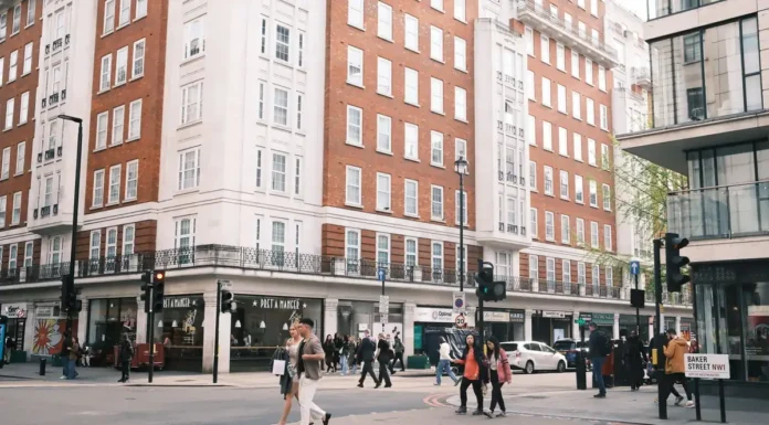 Benefits of Buying an Established Business in London (UK Guide) A busy central London street with shops and offices and people crossing the road