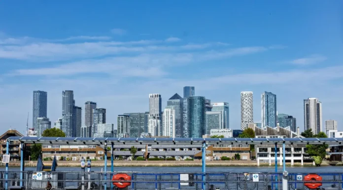 Buying a Business in London: Step-by-Step UK Guide The Canary Wharf skyline in London under a blue sky seen across the water