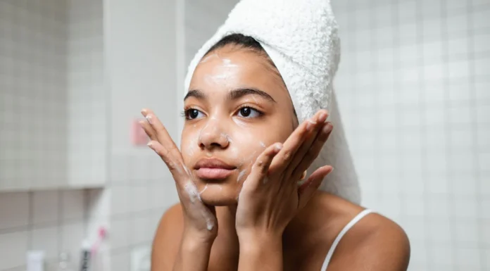 Hormonal Acne in Adults: Causes, Signs and UK Treatment Options Young woman in a towel wrap gently washing her face as part of a skincare routine