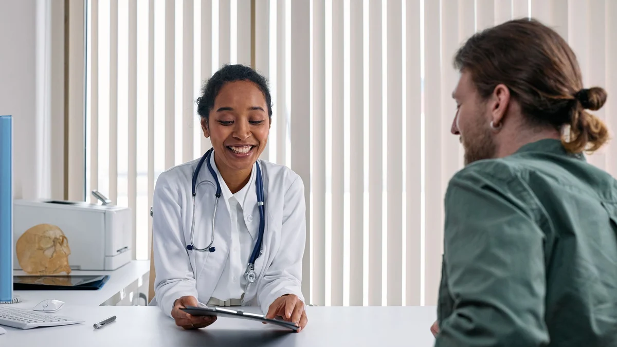 A doctor and a patient talking during a bright, friendly consultation