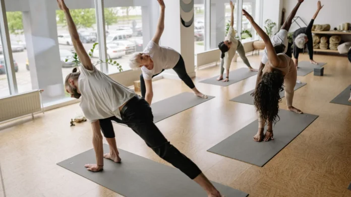 London's Best Health and Wellness Events: What's On in 2026-27 A diverse group of adults doing yoga poses on mats in a bright studio