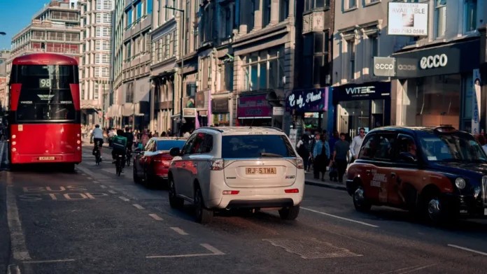 Top Industries for Businesses for Sale in London (Data Guide) A busy London street with a red bus, taxis and shop fronts on both sides
